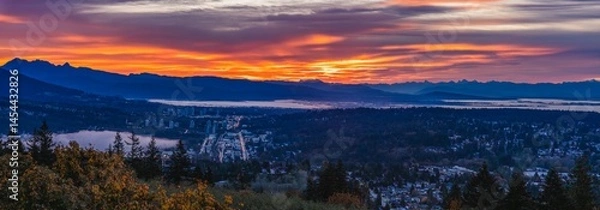 Fototapeta Aerial panoramic view of Fraser Valley, BC, Canada, with dramatic sunrise over mountains in silhouette on horizon.