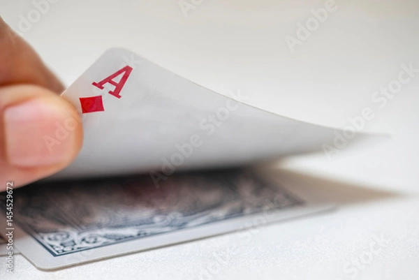 Fototapeta Close-up of a hand raising an ace of diamonds card