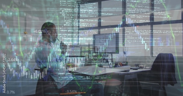 Fototapeta Image of financial data over african american businessman working on laptop in office