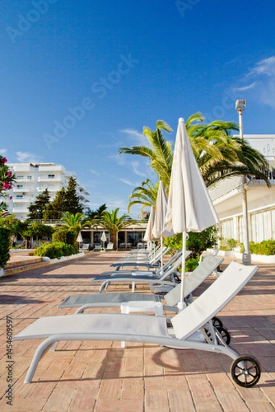 Obraz Empty sunbeds near the pool in the European hotel