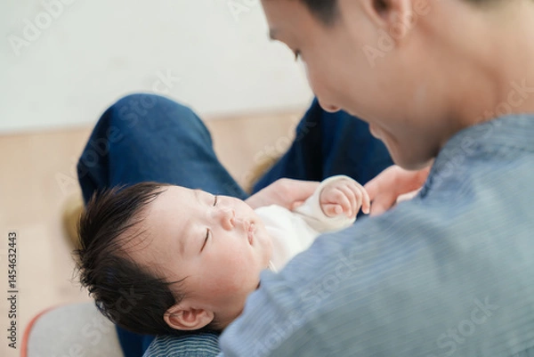 Obraz 眠っている赤ちゃんを抱く男性