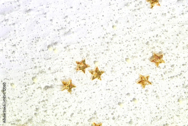 Fototapeta Glittery gold stars on shimmering white textured surface art background.