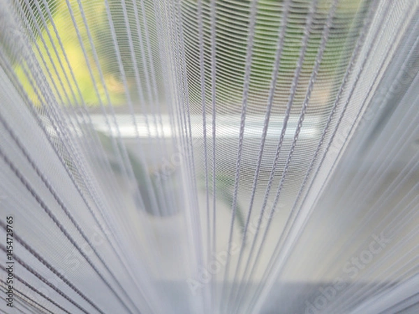 Obraz Close-up view of sheer curtains filtering sunlight in a home setting, creating a soft and serene ambiance in the background, ideal for interior decor themes.