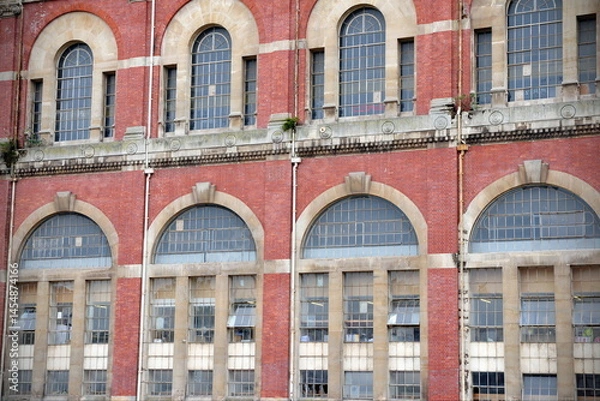 Fototapeta Exterior of an old red brick building with large windows