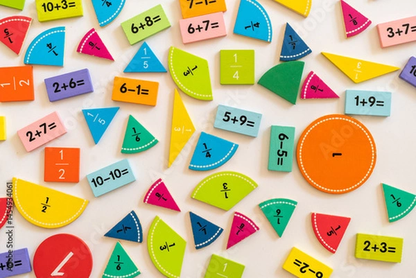 Fototapeta Colorful math manipulatives scattered on a white surface for hands-on learning and educational activities