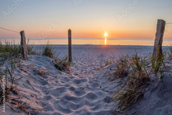 Obraz Sunset over the Baltic Sea at Darß Peninsula showcasing tranquil shoreline and sandy pathway