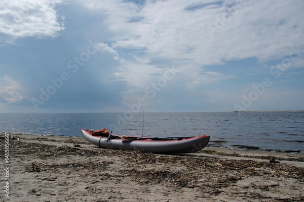 Fototapeta kayak on the shore of the white sea against the backdrop of a stormy sky