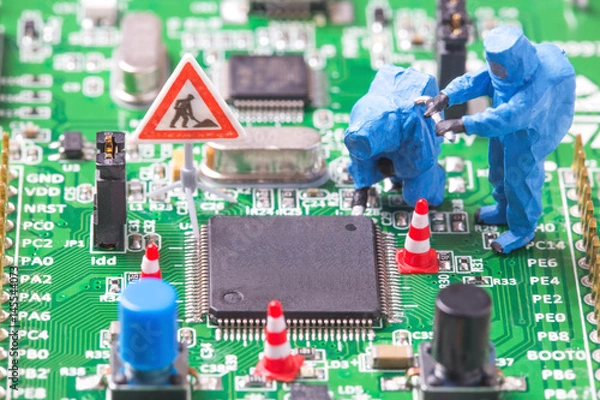 Fototapeta Miniature computer engineers working on a computer circuit board