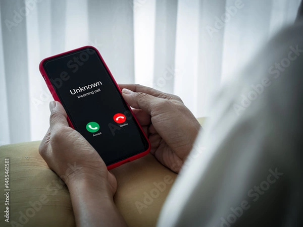Obraz Scam call with unknown caller, scammer calls, fraudulent phone calls concept. Unknown incoming call with accept and decline button show on smart mobile phone screen, holding by senior elderly hands.