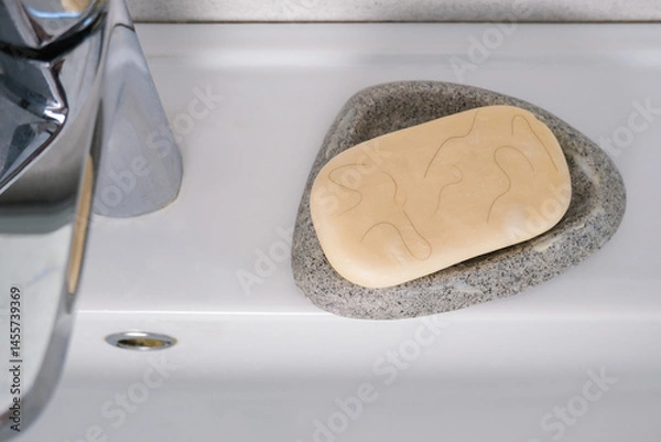 Obraz White soap in a soap dish with hair on the sink