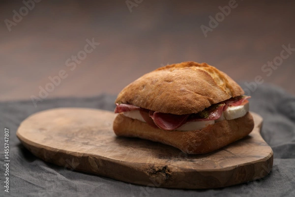 Obraz Sandwich with bresaola, mozzarella and pest on olive board