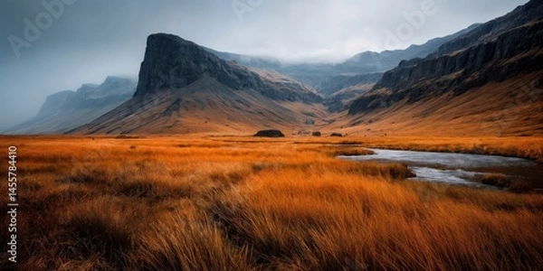 Obraz Misty Cliffside Mountain Rising Above Golden Grass Hillside in Autumn Light, Dramatic Landscape with Steep Rocky Slopes, Rugged Nature Scene Evoking Solitude, Wilderness, and Majestic Elevation