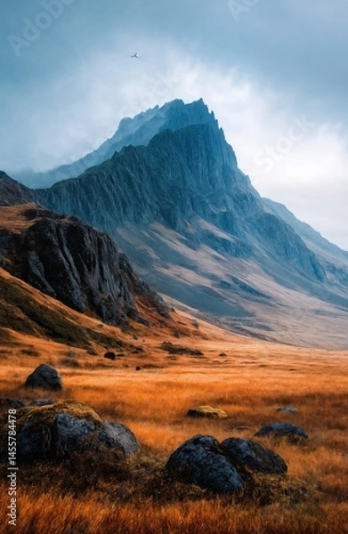 Obraz Misty Cliffside Mountain Rising Above Golden Grass Hillside in Autumn Light, Dramatic Landscape with Steep Rocky Slopes, Rugged Nature Scene Evoking Solitude, Wilderness, and Majestic Elevation