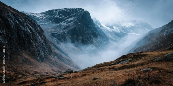 Obraz Misty Cliffside Mountain Rising Above Golden Grass Hillside in Autumn Light, Dramatic Landscape with Steep Rocky Slopes, Rugged Nature Scene Evoking Solitude, Wilderness, and Majestic Elevation