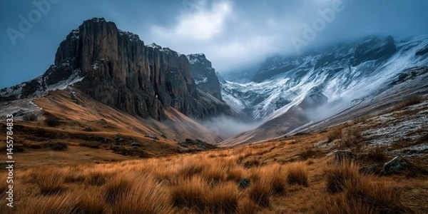 Obraz Misty Cliffside Mountain Rising Above Golden Grass Hillside in Autumn Light, Dramatic Landscape with Steep Rocky Slopes, Rugged Nature Scene Evoking Solitude, Wilderness, and Majestic Elevation