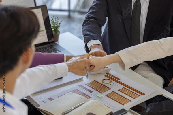 Fototapeta businesspeople are making a high-five gesture or a fist bump or placing their hands together to express their delight at a job well done, employees are sharing their joy at a successful project