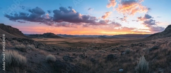 Fototapeta Landscape showcases vast plains at twilight, capturing essence of wilderness under colorful sky.