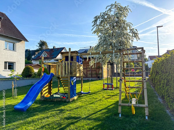 Fototapeta Playground in a garden in Germany with blooming tree in background in spring