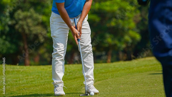 Fototapeta Golfer playing golf in the evening golf course, on sun set evening time.
