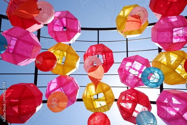 Obraz Vibrant multicolored paper lanterns sway gently against a brilliant azure sky