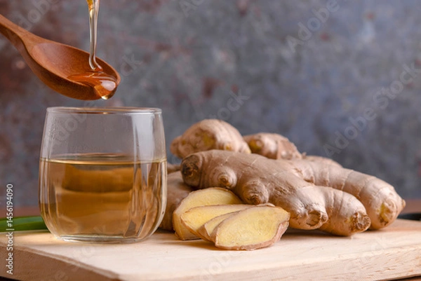 Fototapeta Cup of tea with ginger root on a wooden table, Ginger tea with and honey on a gray background.