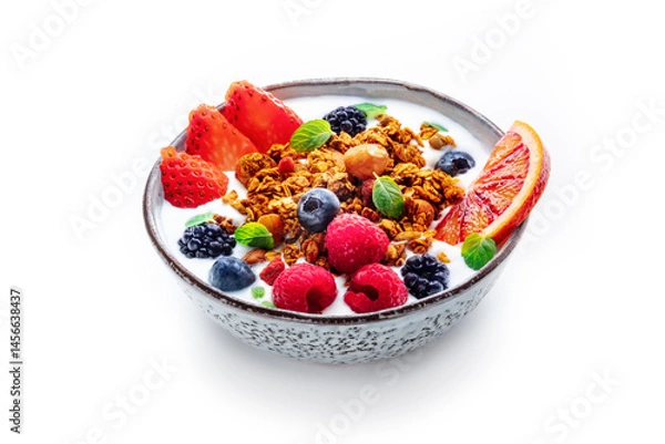 Fototapeta Granola with yogurt and fresh fruit. Organic gourmet muesli with strawberry, blueberry, raspberry, mint, and orange, on a white background