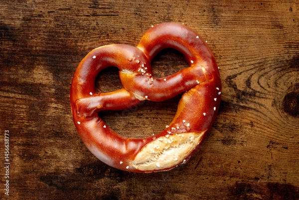 Fototapeta Pretzel or Bretzel, traditional German beer snack, a wheat bread with salt, overhead flat lay shot on a wooden background