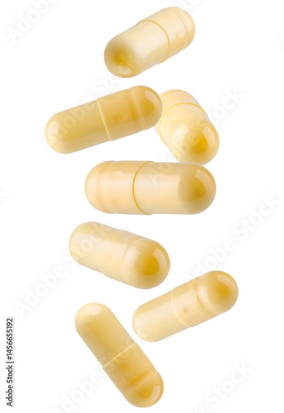 Fototapeta Yellow capsule pills falling in space. Isolated on white.