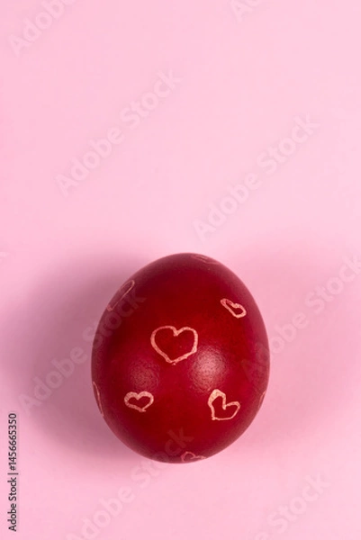 Fototapeta Red painted Easter egg with white hearts on a pink background