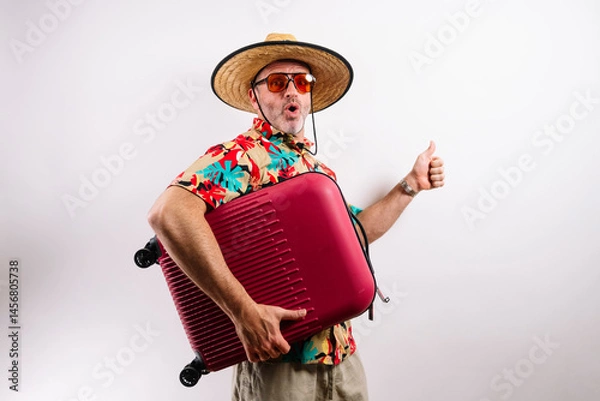 Fototapeta Funny tourist hugging suitcase and thumbs up