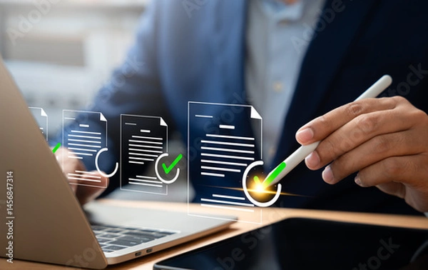 Fototapeta Digital document verification, Businessman using laptop and tablet to approve digital document, Review online forms,Quality assessments virtual checklist for performance tracking,Business management