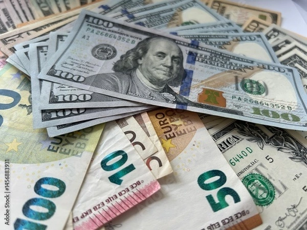 Fototapeta Close-up shot of Euro and US Dollar banknotes scattered on a flat surface, symbolizing global finance and currency exchange.