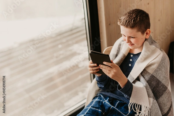 Fototapeta Teenager Boy in Pajama Reading Book at Home