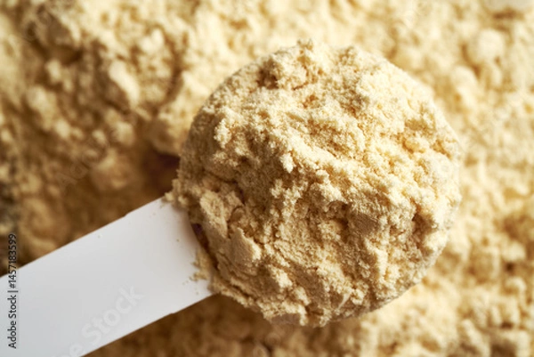 Fototapeta Whey protein powder in a measuring scoop, top view