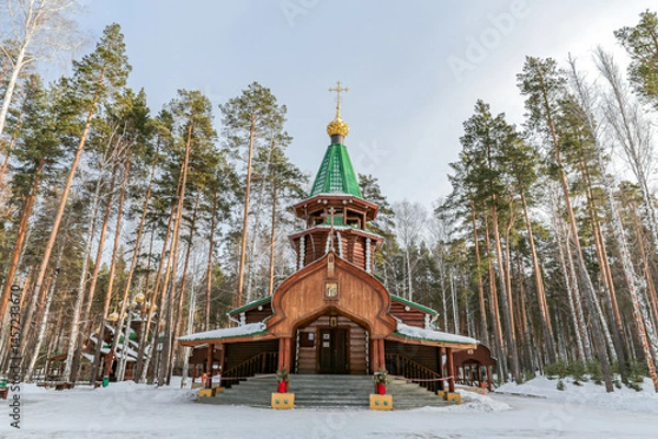 Obraz A small wooden church with golden domes and a cross on top of it in Yekaterenburg Russia
