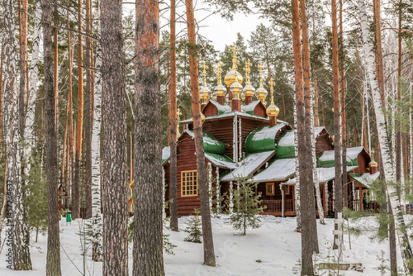 Obraz A small wooden church with golden domes and a cross on top of it in Yekaterenburg Russia