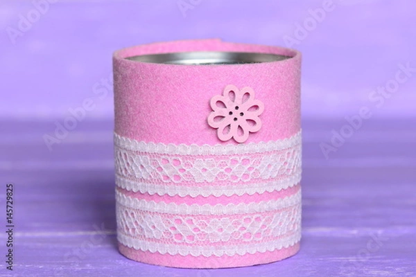Obraz Recycled can isolated on wood background. Tin can decorated with felt, lace and flower button. Inexpensive way to make craft projects for home. Recycling tin can into organizer or planter for kitchen