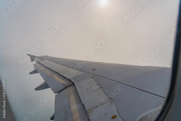 Fototapeta Soaring above the clouds on a misty journey through the endless sky during a calm afternoon flight