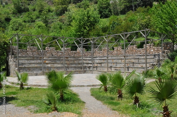 Fototapeta Ruins of Ancient Amphitheater Surrounded by Lush Greenery