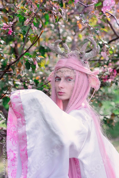 Fototapeta Deer dryad girl against the background of a blooming pink apple tree