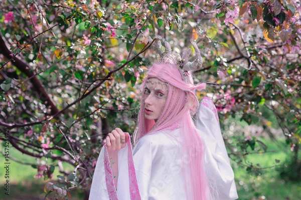 Fototapeta Deer dryad girl against the background of a blooming pink apple tree