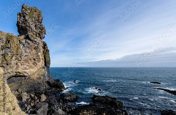 Fototapeta A high resolution view of Lóndrangar natural volcanic rock tower extending out into the ocean in Snæfellsjökull National Park in Western Iceland.