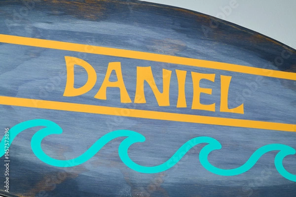 Fototapeta Painted Name Daniel on Blue and Yellow Decorative Surface
