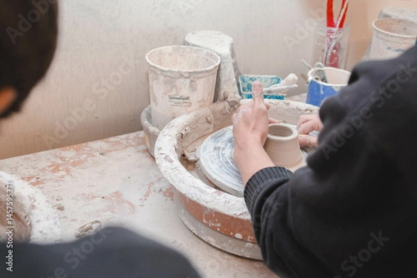 Fototapeta person making a ceramics in an art class hands making pottery 