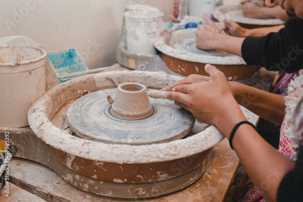 Fototapeta hands of a potter making a bowl spinning 