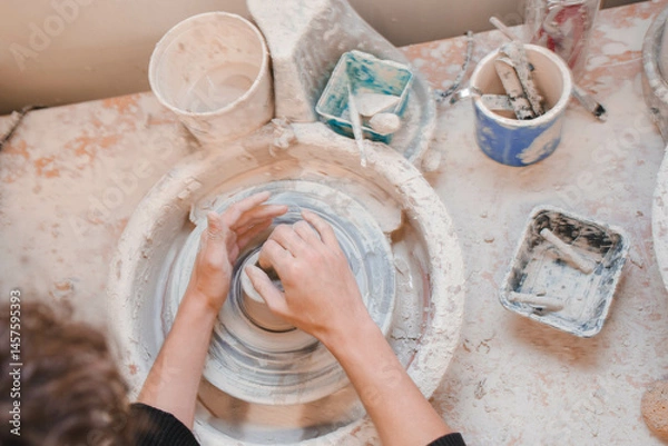 Fototapeta person making pottery in and wheel 