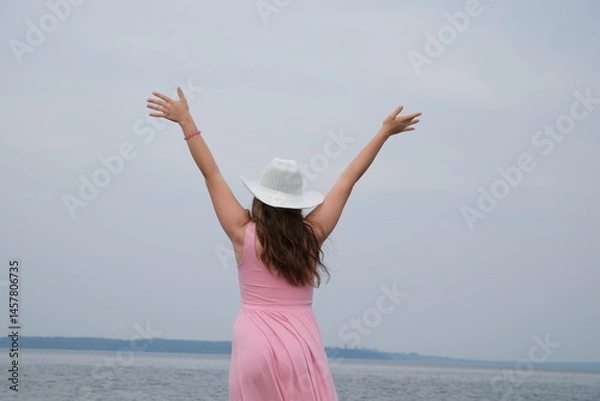 Obraz Happy Woman with Raised Arms By the Sea. Joyful girl with outstretched arms up in the air celebrating nature . High quality photo