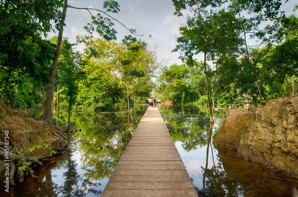 Fototapeta The wooden path towards to Neak Pean temple on artificial island. Angkor.