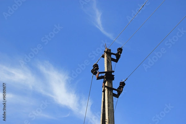 Fototapeta The electric power transmission pillar and wires on a background of the sky