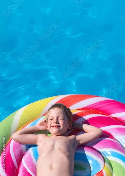Obraz child lies on a colorful inflatable mattress in the swimming pool
